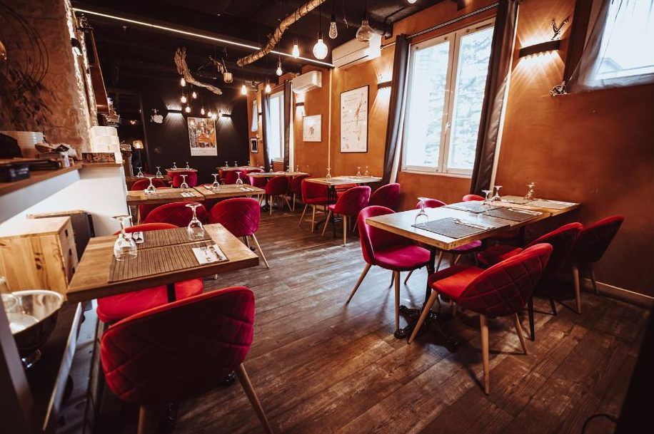 Salle du Filanthrope avec tables en bois et fauteuils rouges